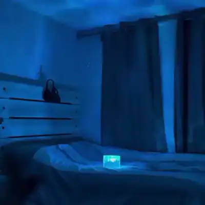 Un cuarto oscuro con olas de luz azul en el techo y las paredes