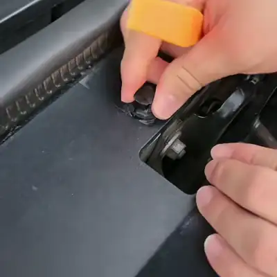 Una mano saca la grapa vieja y empuja una grapa nueva en el panel del carro
